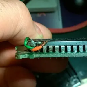 A close-up view of a homemade modification made to two ROM chip pins on an Atari 2600 Frostbite cartridge.