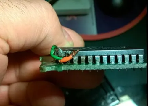 A close-up view of a homemade modification made to two ROM chip pins on an Atari 2600 Frostbite cartridge.