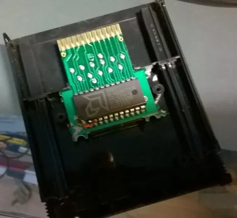Photo (slightly blurry) showing the inside of the Frostbite 2600 cartridge; one can discern that something has been modified where the ROM chip pins meet the PCB.