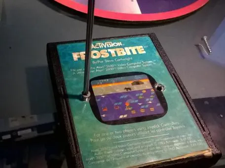Photo depicting a screw being removed from the front of a Frostbite cartridge for the Atari 2600