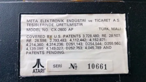 A close-up photo of the manufacturer's sticker on the bottom of the ME-TA produced Atari 2600 console.
